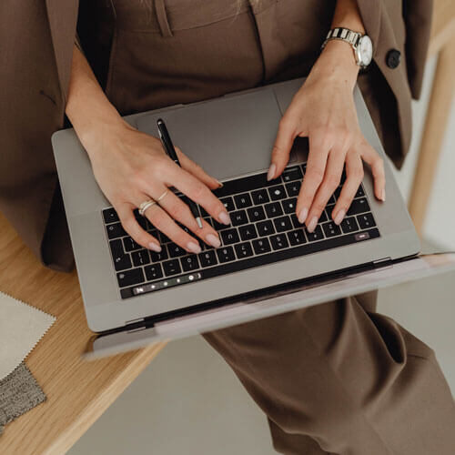 kaboompics_young-entrepreneur-dressed-in-brown-suit-holds-laptop-27938